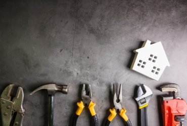 Wooden house and construction tools on stone pattern background with copy space.Home Repair concept, Repair maintenance concept, Renovation concept.