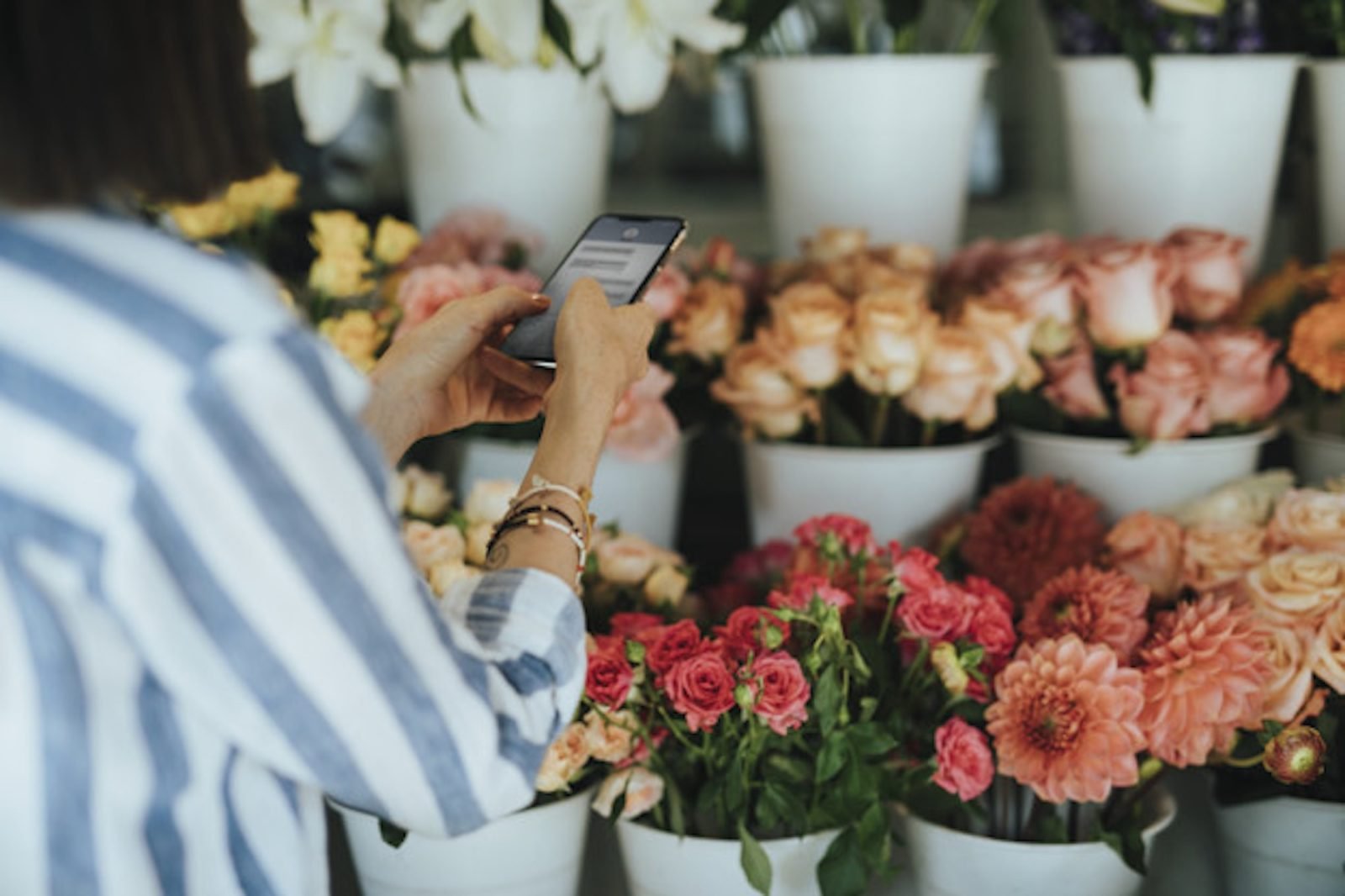 Woman messaging in a flower shop