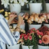 Woman messaging in a flower shop
