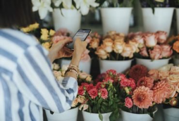 Woman messaging in a flower shop