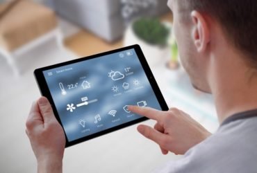 Smart home control on tablet. Interior of living room in the background.