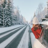 Magic car trip on the road by winter forest covered by snow